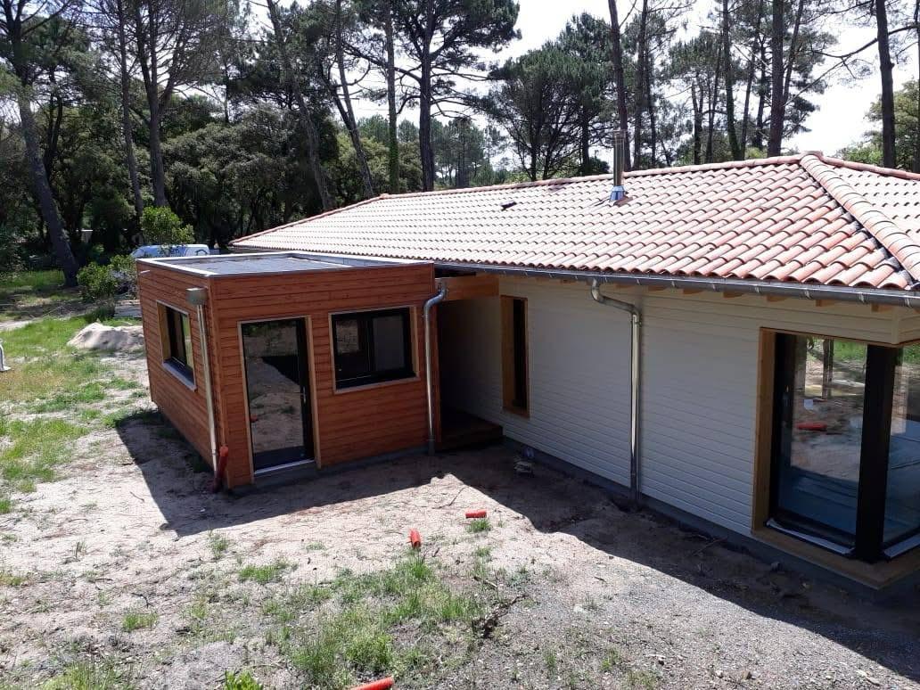 Maison individuelle avec un volume en bois et une entrée abritée