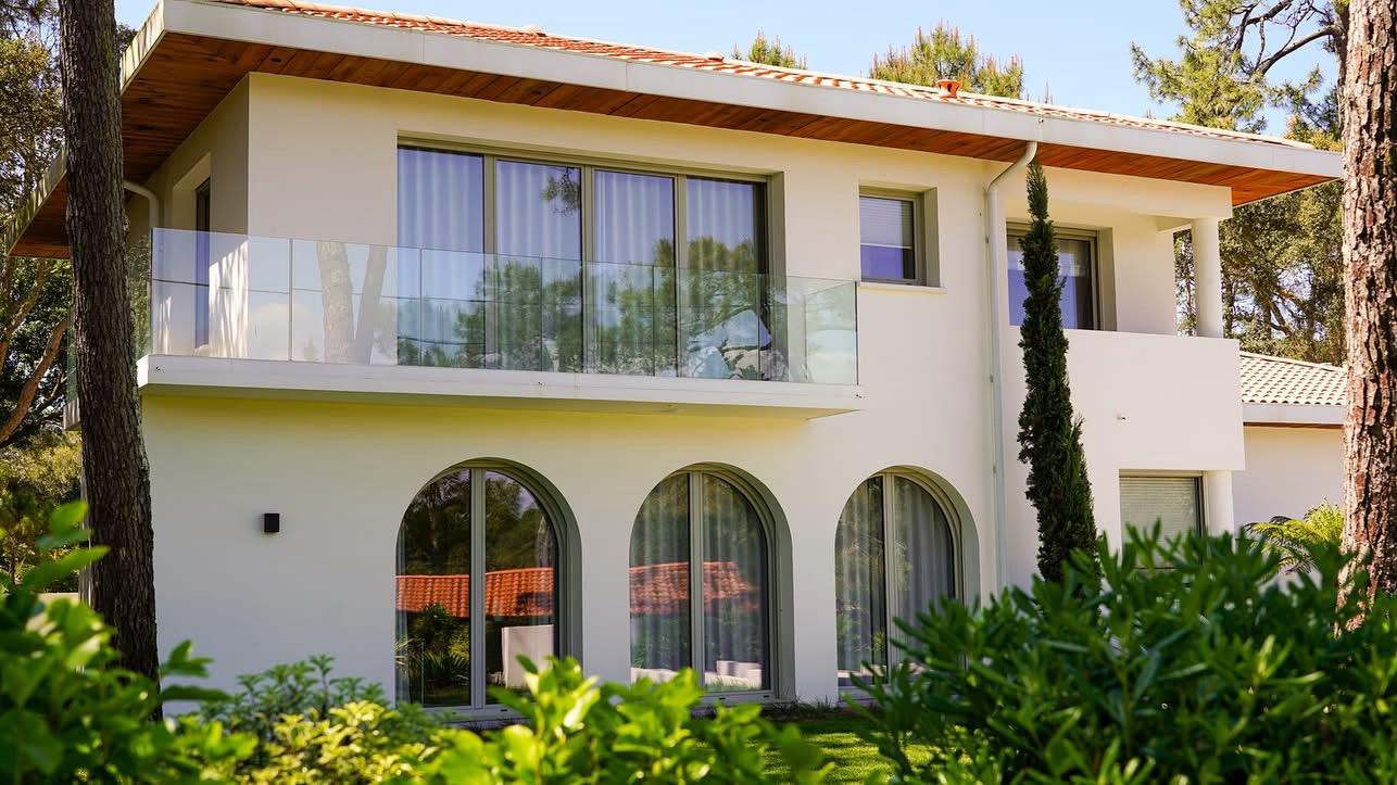 Maison rénovée avec ouvertures cintrées et balcon